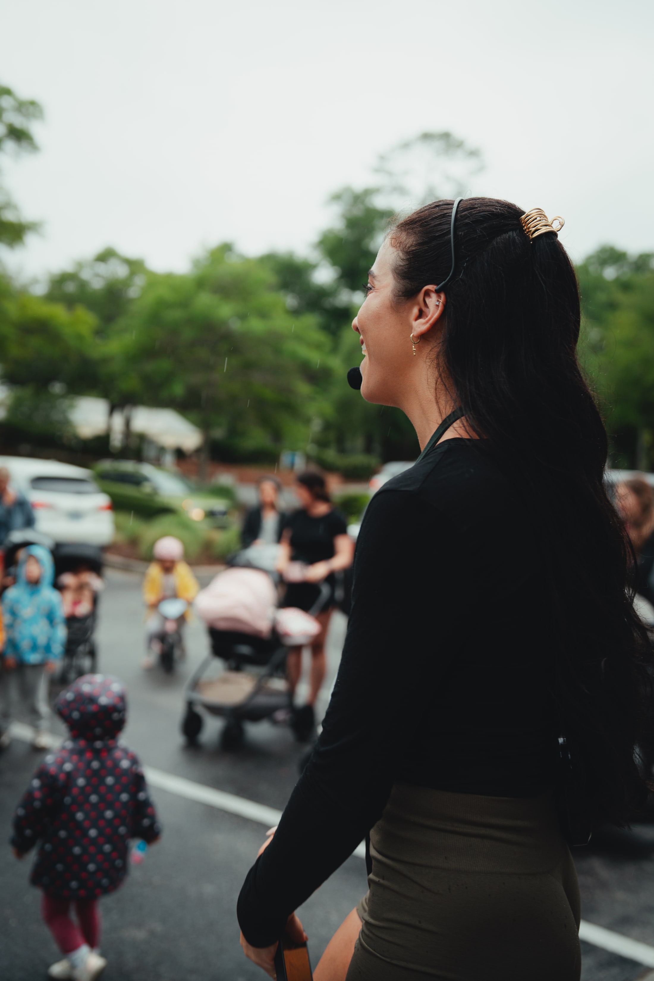 Brooke speaking to a crowd of moms with strollers and toddlers in the background